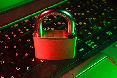 Red padlock on a computer keyboard, representing cybersecurity enforcement